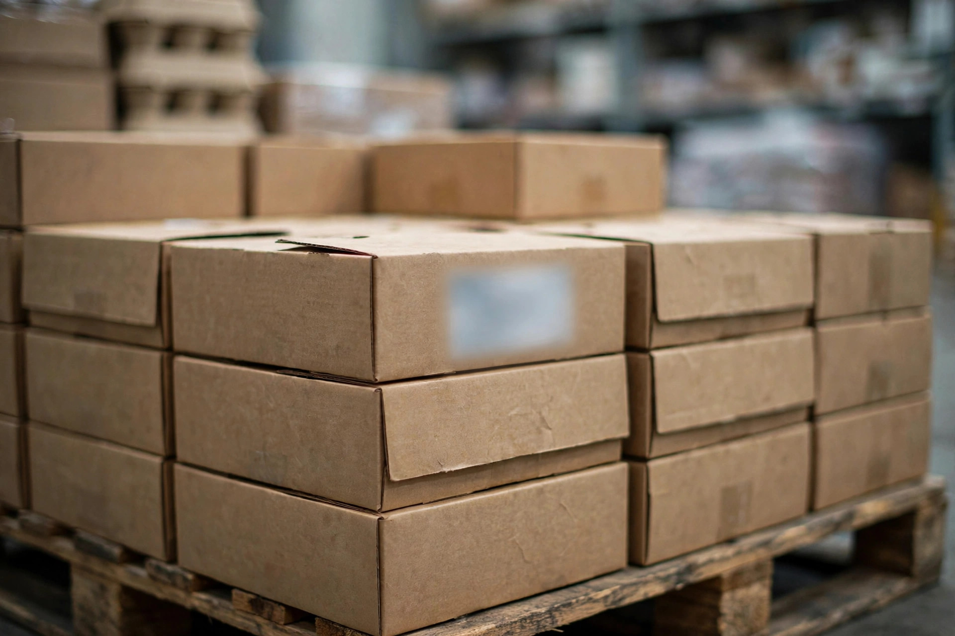 Stacked food cartons on a pallet with blurred batch labels