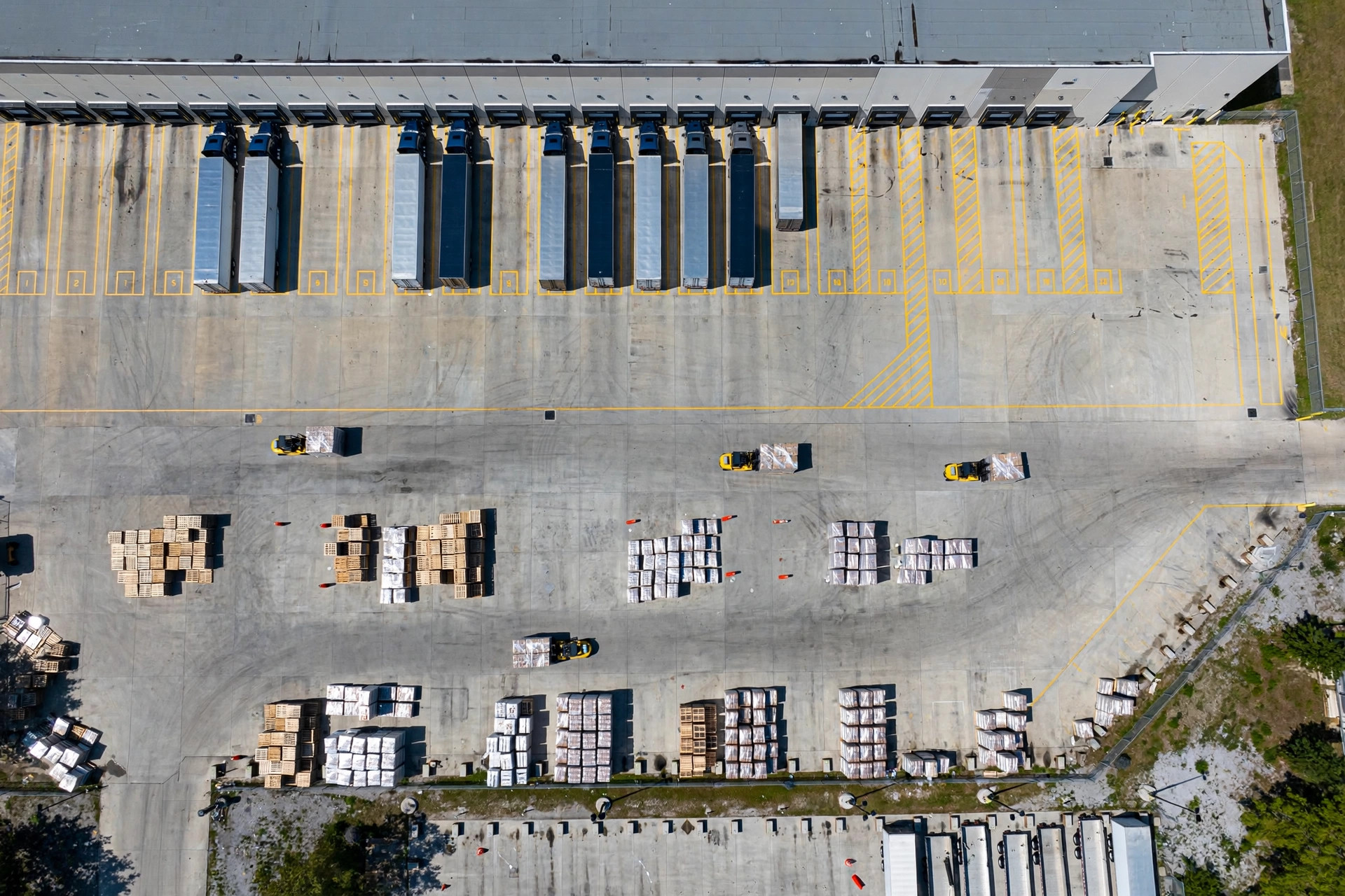 Aerial view of a warehouse dock apron with trailers working multiple dock positions